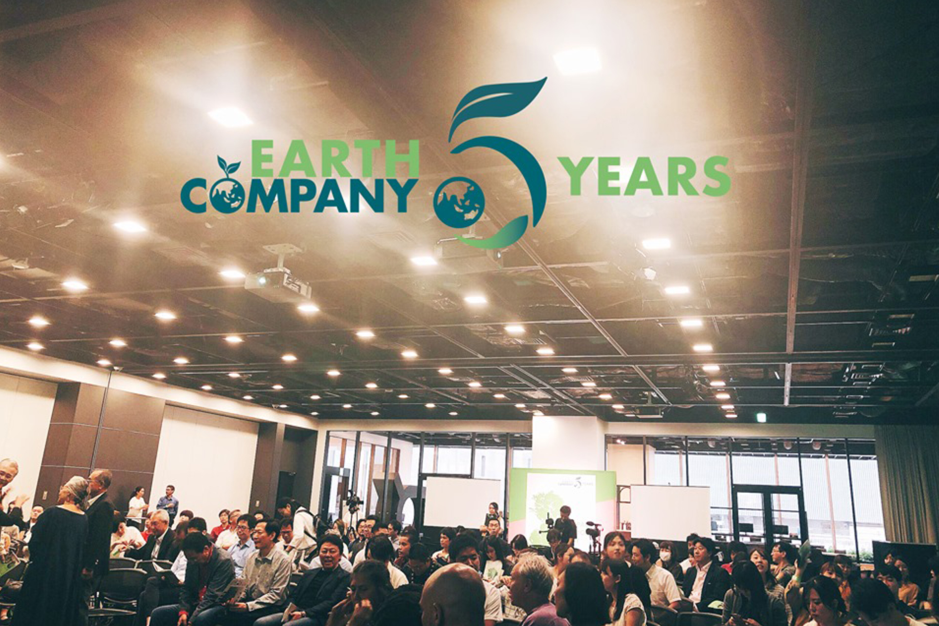 イベント当日の会場全体を写した写真に「Earth Company 5 years」のロゴをのせたイメージ写真