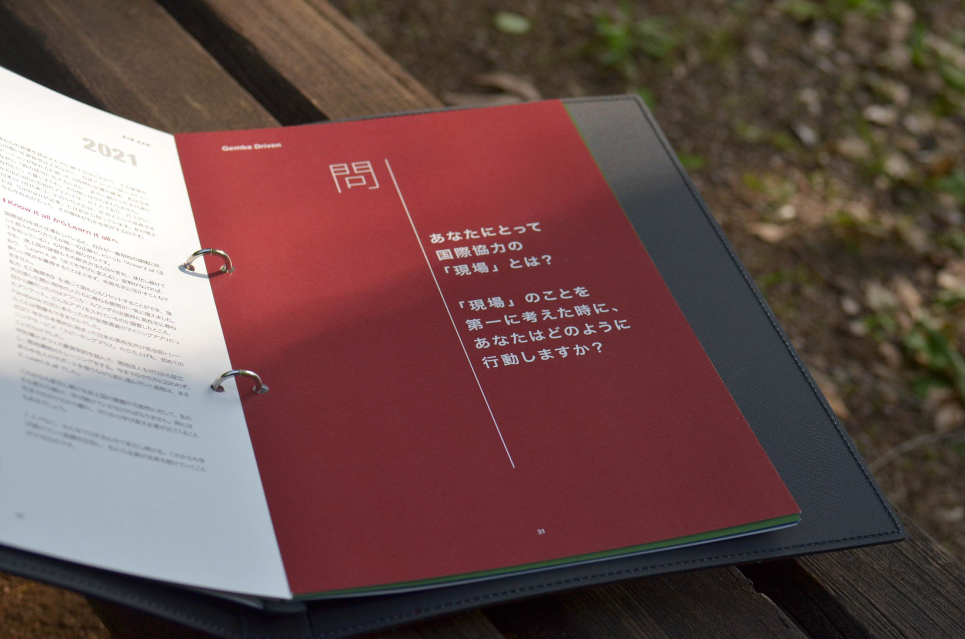 NPO法人e-Educationの社員向け冊子飲み開きの写真。ページには「あなたにとって国際協力の現場とは？」と記載されている。