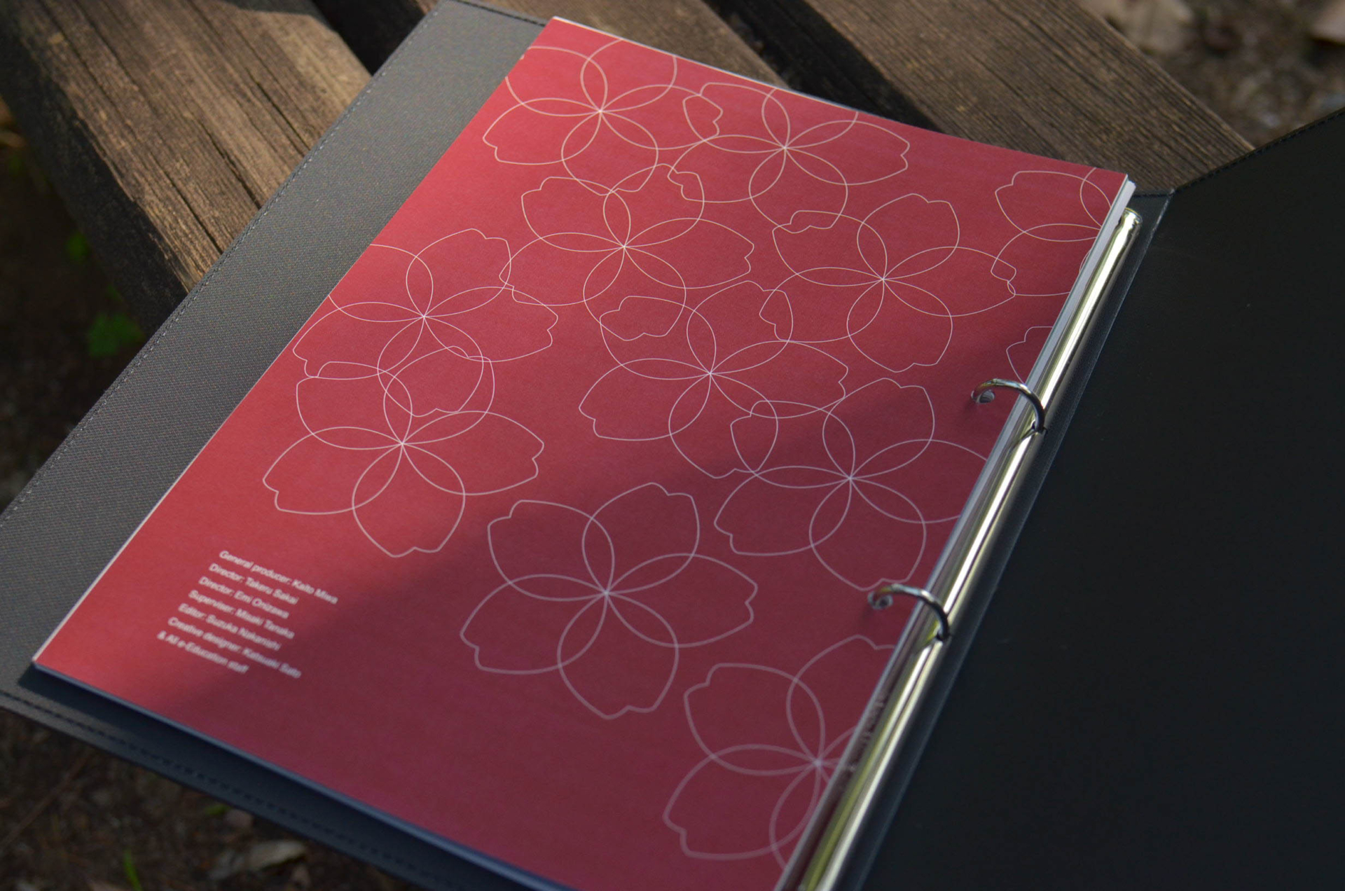 NPO法人e-Educationの社員向け冊子飲み開きの写真。ページにはe-Educationのモチーフである桜のイラストがあしらわれている